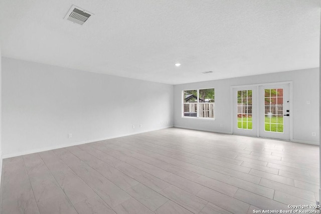 11202 Forest Pass, Live Oak, TX 78233 - empty room featuring a textured ceiling, baseboards, wood finished floors, and visible vents