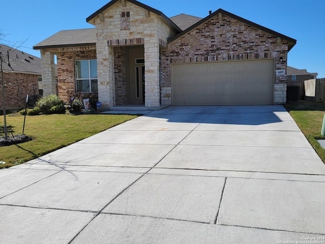 french country home with an attached garage, driveway, stone siding, and a front lawn