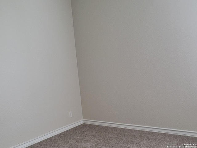 carpeted spare room featuring baseboards