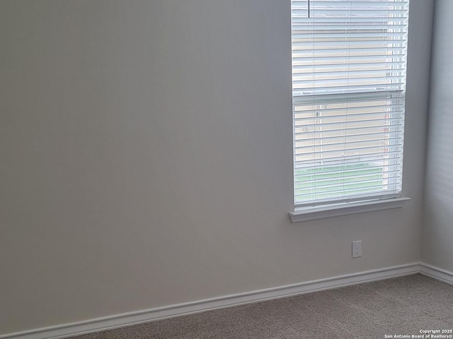carpeted spare room with baseboards