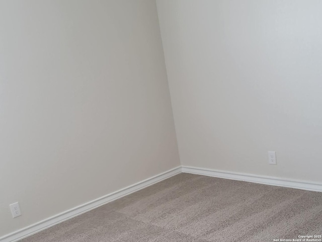 unfurnished room featuring carpet floors and baseboards