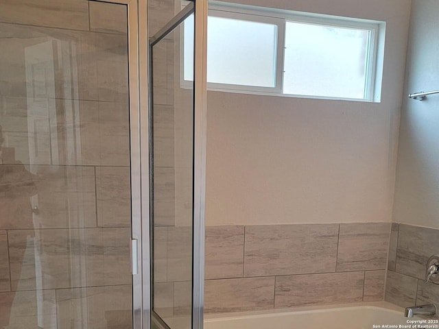 bathroom with a shower stall and a garden tub