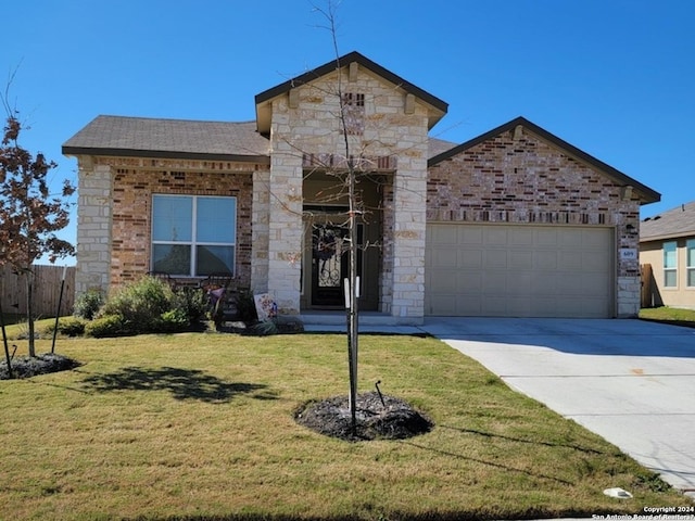 view of front of home with an attached garage, fence, driveway, and a front yard
