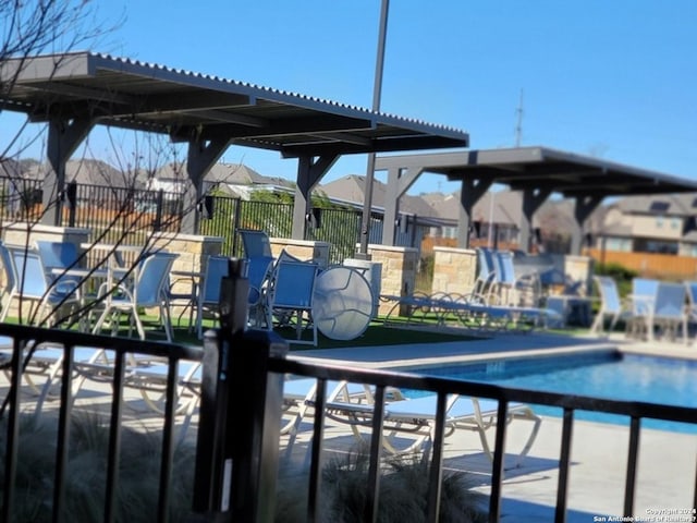 community pool featuring fence and a residential view