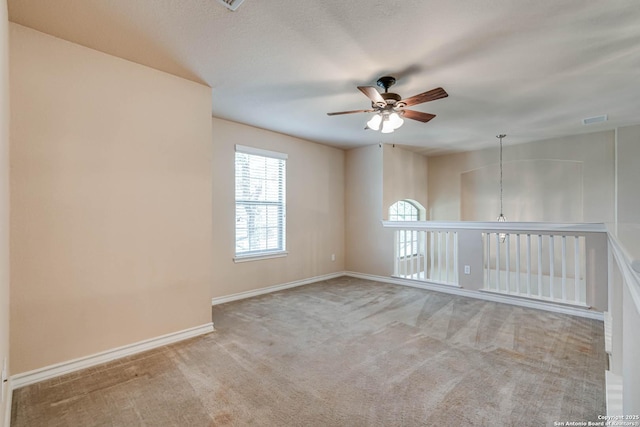 unfurnished room with baseboards, carpet flooring, ceiling fan, and a healthy amount of sunlight