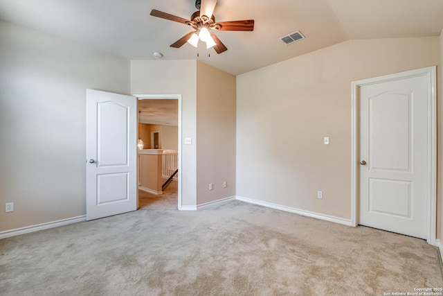unfurnished bedroom featuring visible vents, carpet floors, lofted ceiling, baseboards, and a ceiling fan