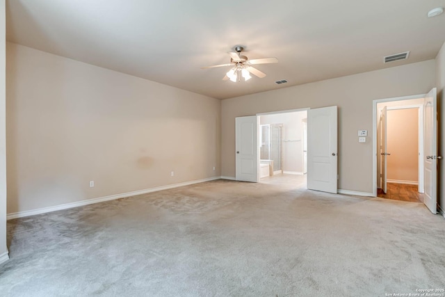 unfurnished bedroom with visible vents, light carpet, baseboards, ensuite bathroom, and ceiling fan