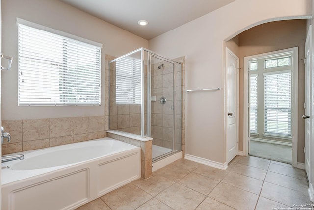 bathroom featuring tile patterned floors, baseboards, a stall shower, and a bath