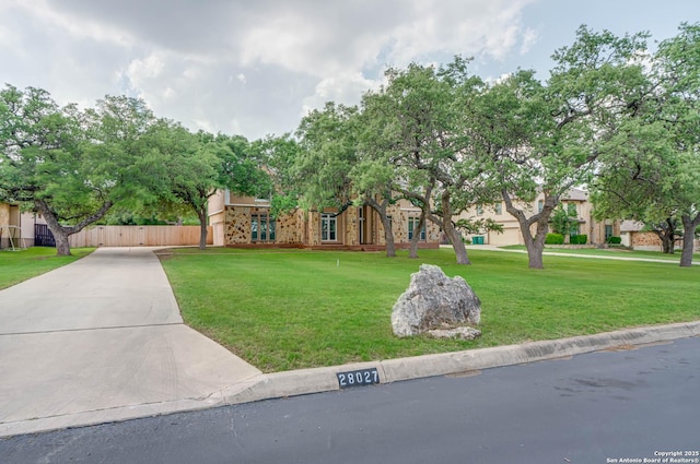 view of front of house featuring fence and a front lawn