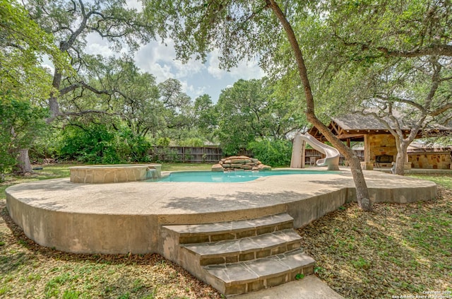 view of pool with a patio, a water slide, a fenced in pool, and fence