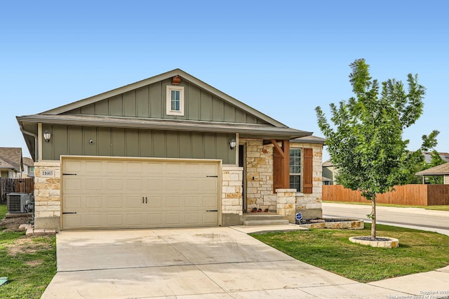 craftsman-style home with fence, stone siding, concrete driveway, an attached garage, and central air condition unit
