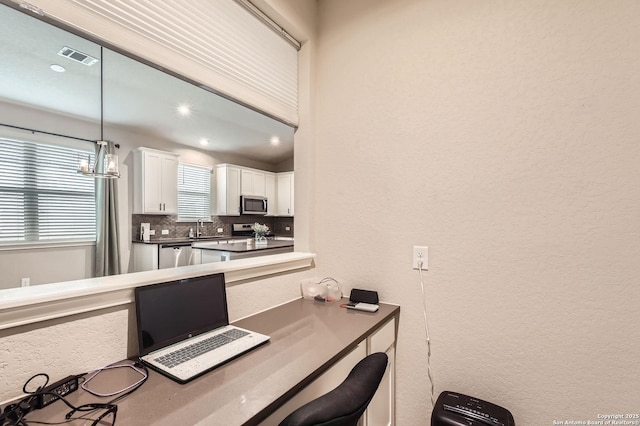 office area with a textured wall, a sink, a chandelier, recessed lighting, and visible vents