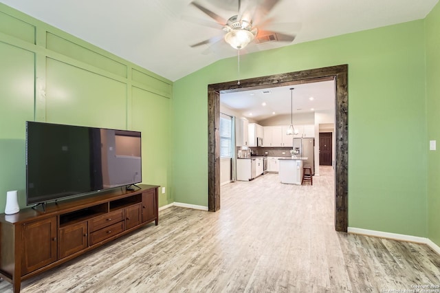 unfurnished living room featuring light wood-style floors, baseboards, a ceiling fan, and lofted ceiling