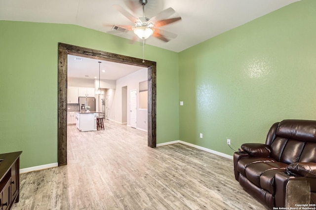 living area with baseboards, ceiling fan, light wood-type flooring, and visible vents