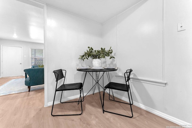 dining space with baseboards and wood finished floors