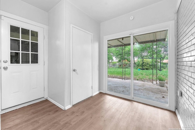 doorway to outside with baseboards and light wood-style flooring