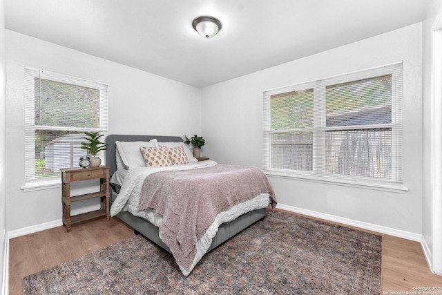 bedroom featuring baseboards and wood finished floors