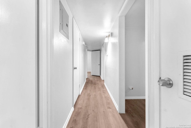 hall with baseboards and light wood-type flooring