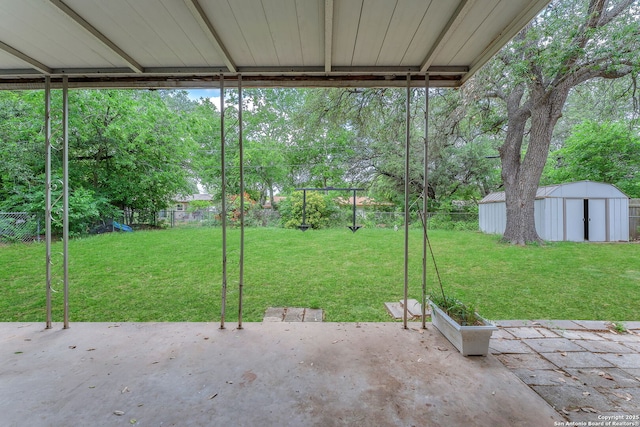 view of yard with a storage shed, a patio, an outbuilding, and a fenced backyard