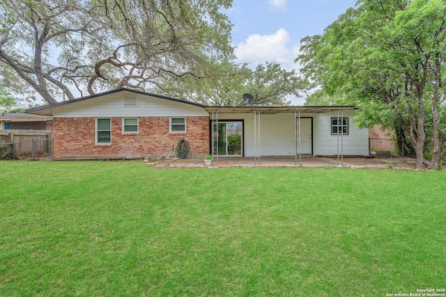 back of property featuring fence, a patio, a yard, and brick siding