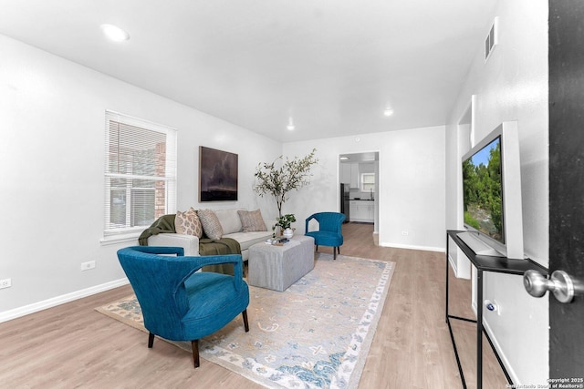 living room featuring baseboards, recessed lighting, and wood finished floors