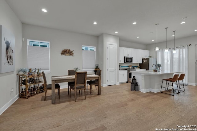 dining space featuring recessed lighting, baseboards, and light wood-style floors