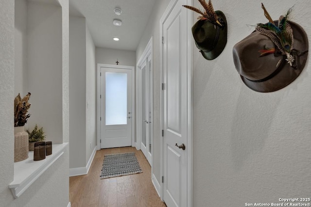 corridor featuring recessed lighting, baseboards, and light wood-type flooring