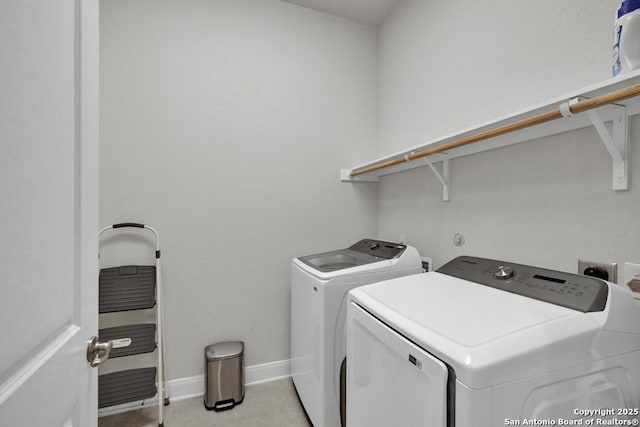 laundry area featuring light tile patterned floors, baseboards, laundry area, and washer and clothes dryer