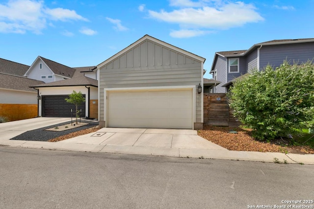 view of front facade with an attached garage, board and batten siding, and concrete driveway