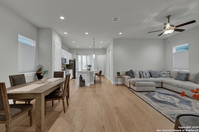 living area with a ceiling fan, recessed lighting, light wood-style flooring, and visible vents