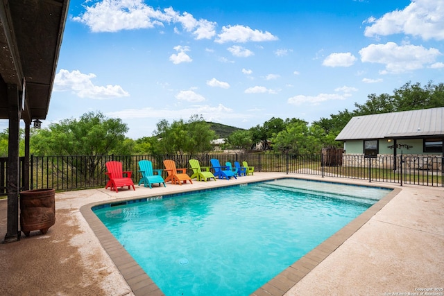 pool with a patio area and fence