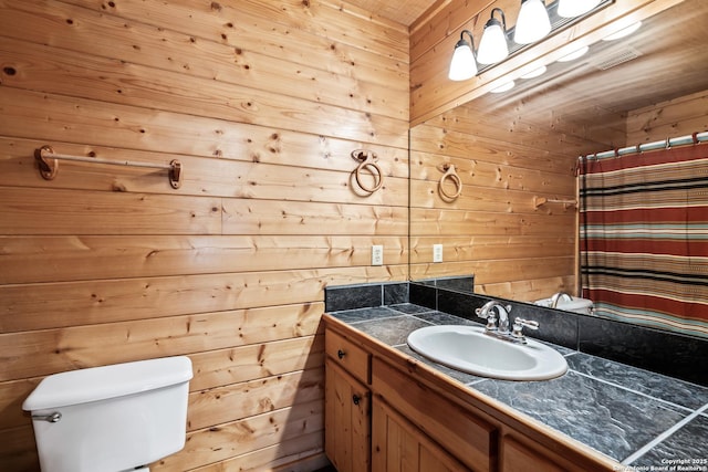 bathroom featuring wooden walls, toilet, curtained shower, and vanity