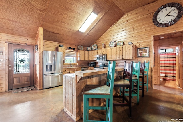 kitchen featuring wooden walls, light countertops, stainless steel appliances, and lofted ceiling