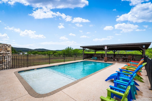 view of pool featuring a fenced in pool, a mountain view, a patio, and fence