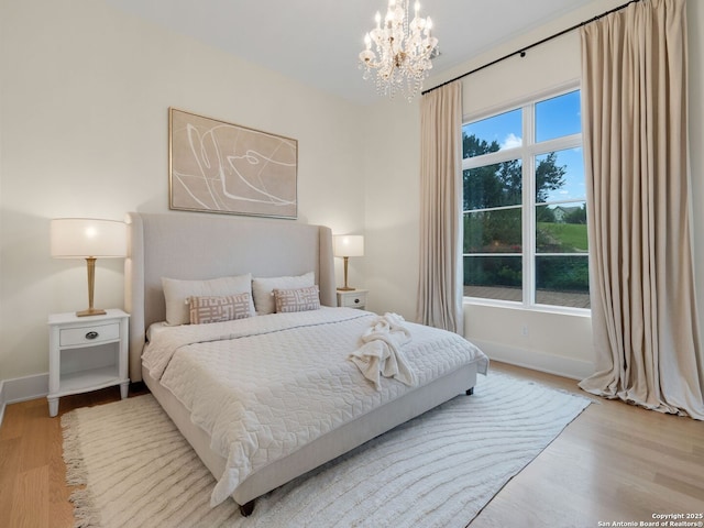 4701 Peralta Ln, Austin, TX 78735 - bedroom with an inviting chandelier, baseboards, and wood finished floors