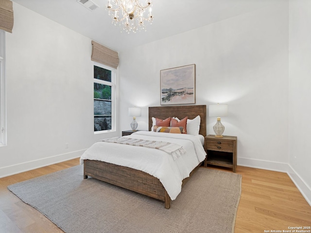4701 Peralta Ln, Austin, TX 78735 - bedroom featuring baseboards, visible vents, an inviting chandelier, and wood finished floors