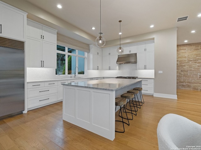 4701 Peralta Ln, Austin, TX 78735 - kitchen with appliances with stainless steel finishes, a sink, under cabinet range hood, visible vents, and a kitchen island