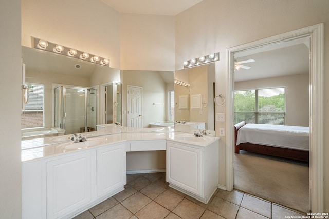 ensuite bathroom featuring tile patterned flooring, a sink, ceiling fan, and a stall shower