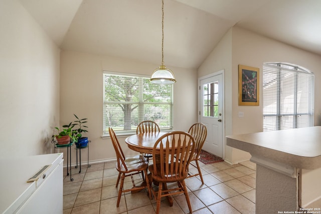 dining space with baseboards, light tile patterned flooring, and lofted ceiling