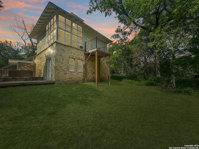 1262 Sleepy Holw, New Braunfels, TX 78130 - back of house at dusk with a balcony, a yard, and stone siding