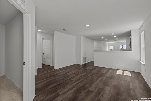 unfurnished living room featuring baseboards, dark wood-style flooring, recessed lighting, and visible vents
