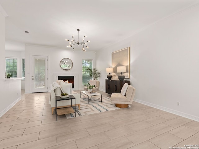 living area featuring crown molding, baseboards, a chandelier, and a healthy amount of sunlight