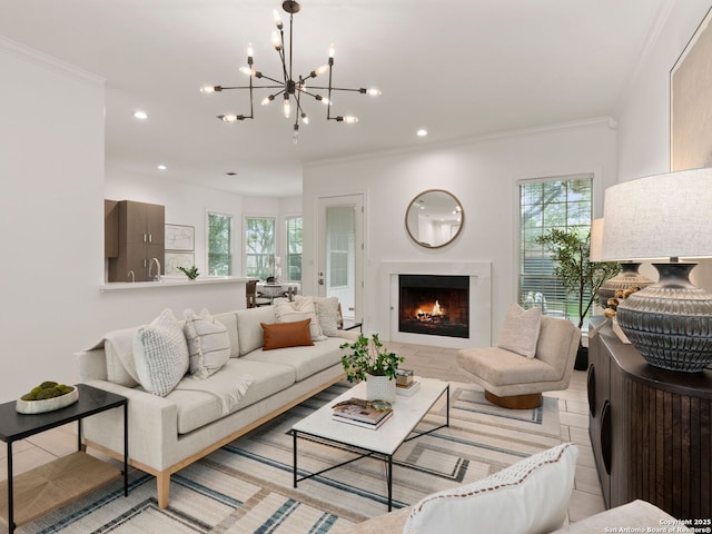 living room with crown molding, a lit fireplace, recessed lighting, and a chandelier