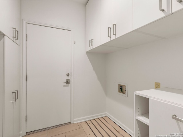 laundry area featuring cabinet space, baseboards, and washer hookup