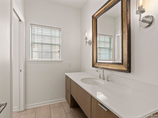 bathroom featuring vanity, baseboards, and tile patterned floors