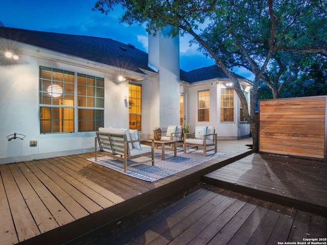 deck at dusk featuring an outdoor hangout area