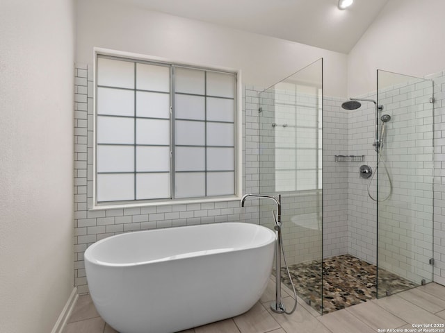 bathroom with tile patterned floors, a soaking tub, and tiled shower