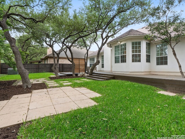 view of yard featuring fence, a patio, and a wooden deck