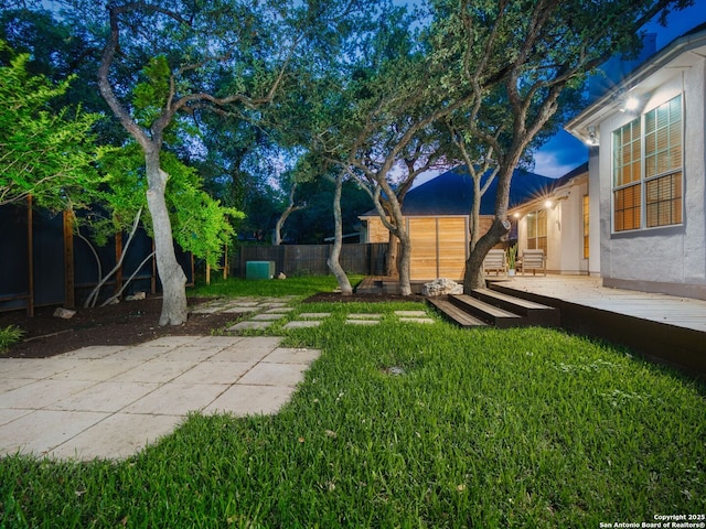view of yard featuring a wooden deck, a fenced backyard, and a patio area