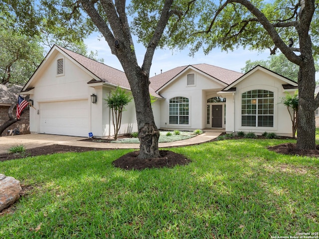 ranch-style house with a garage, a front lawn, concrete driveway, a shingled roof, and stucco siding